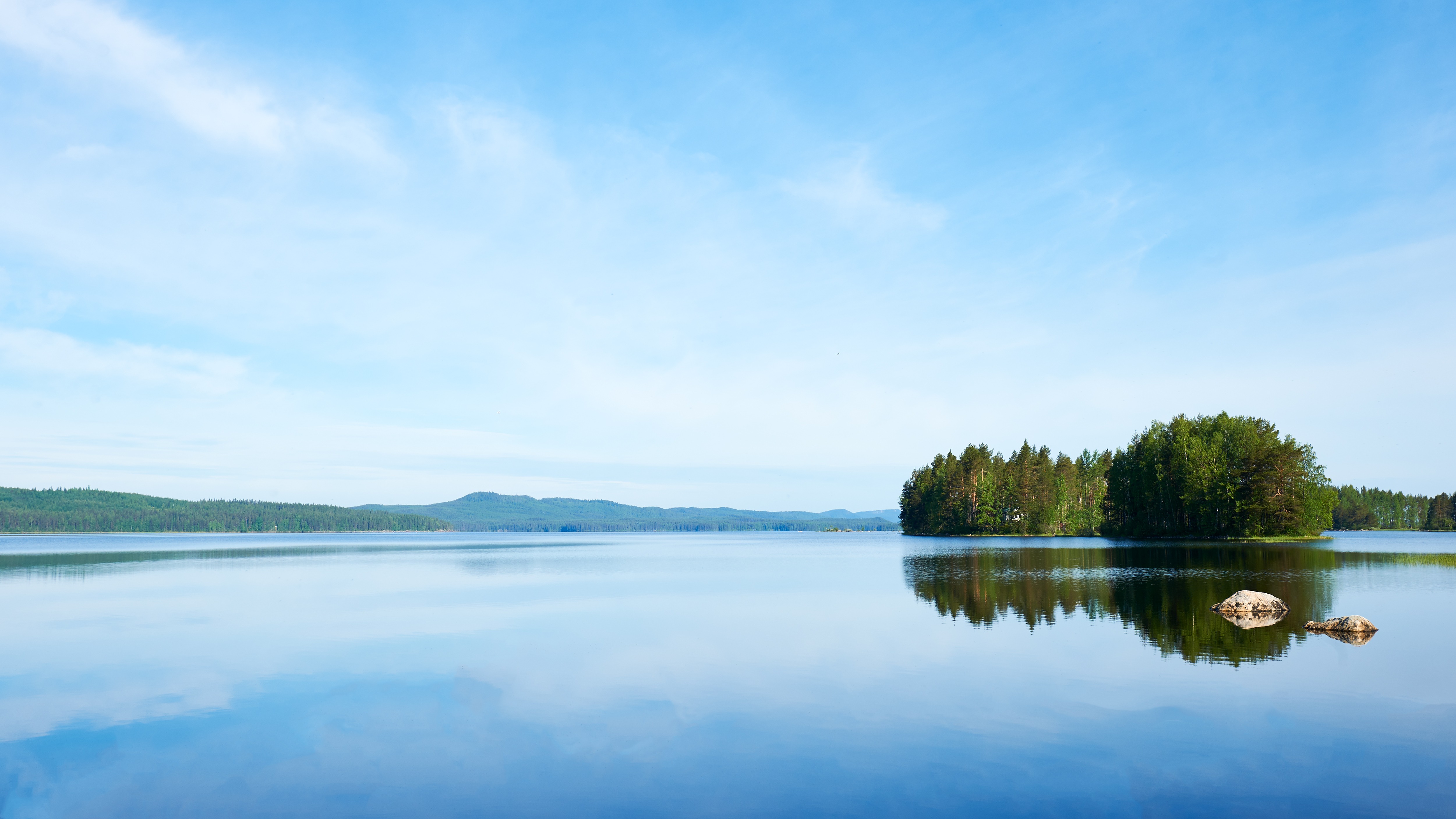 Ett stilla nordiskt sjölandskap med en skogsö